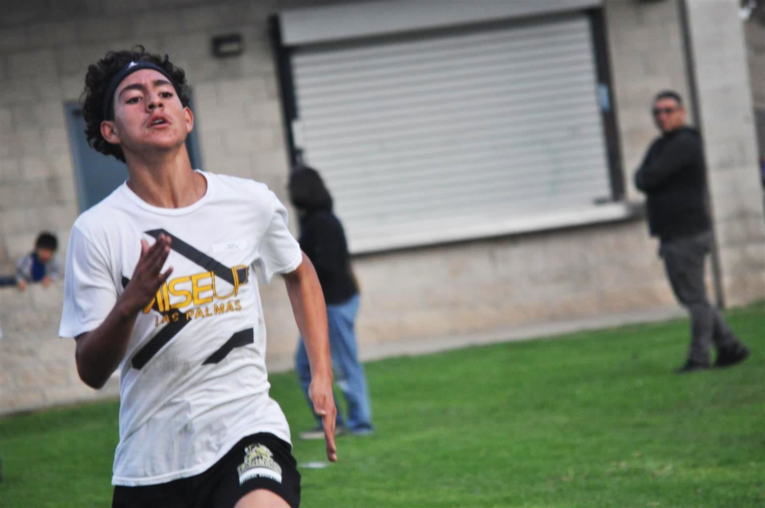 Male student runs in Cross Country competition